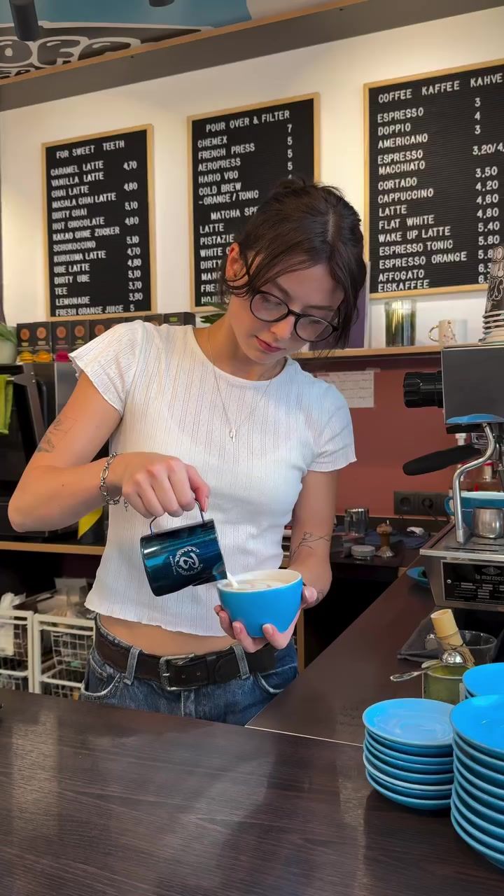 The three letterboard menus behind the bar, a barista working below