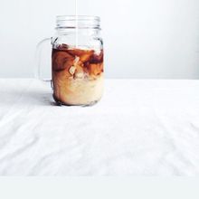 Cold brew with milk swirling in a mason jar